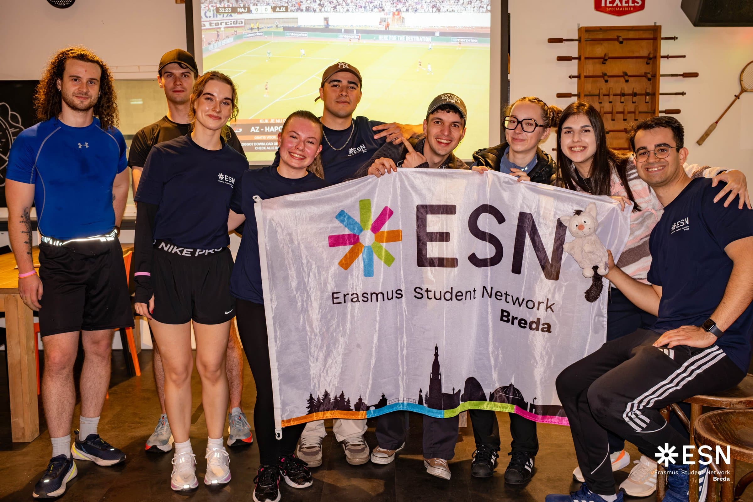 The ESN Breda team gathered behind their flag at a sports event